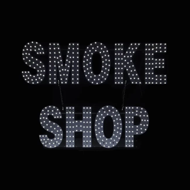 LED smoke shop sign with bright white lights on black background for storefront display.