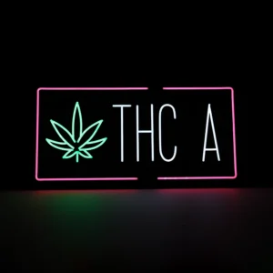 Vibrant multicolor THC-A neon LED flex sign for dispensaries and smoke shops. Features a glowing green cannabis leaf icon and "THC A" in white text, framed by a pink rectangular border. 34x17 inch storefront display.
