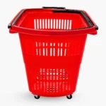 A front-facing view of a red plastic shopping basket on four wheels, showing the perforated design and black carrying handles folded against the rim.